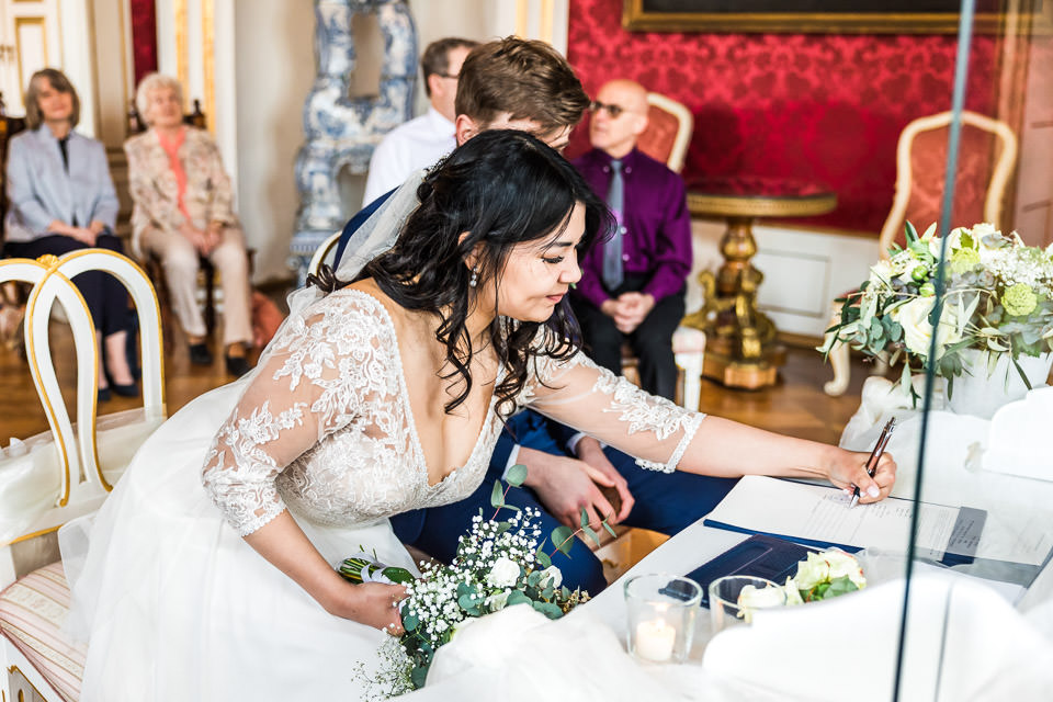 Braut unterschreibt bei standesamtlicher Trauung auf Schloss Detmold