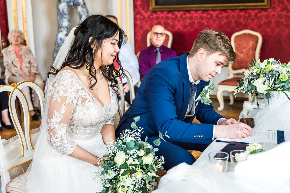 Bräutigam unterschreibt bei standesamtlicher Trauung auf Schloss Detmold