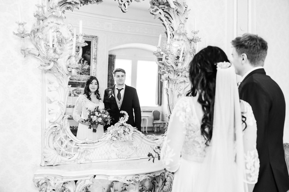 Hochzeitspaar betrachtet sich stolz im Spiegel