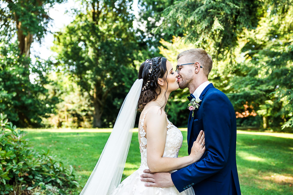 Brautpaar küsst sich im Garten der Remise Niederbarkhausen