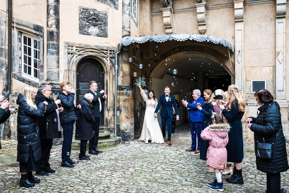 Hochzeitsgäste empfangen das Brautpaar mit Seifenblasen