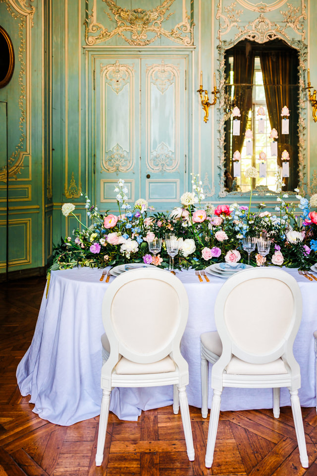 Stilvolle Stühle in Creme vervollständigen die französische Hochzeitstafel.