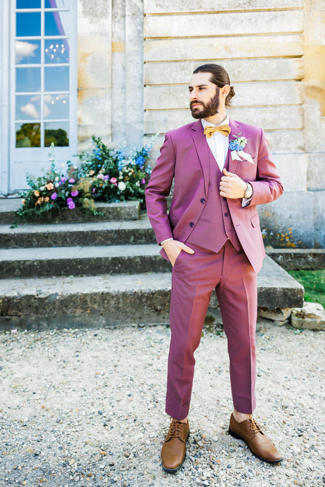 Bräutigam präsentiert seinen violetten Hochzeitsanzug.
