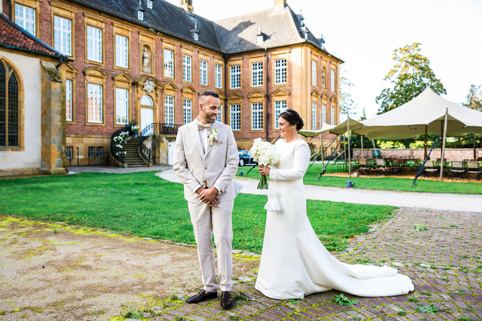 First Look an der Alten Abtei der  Klosterpforte Marienfeld. Der Bräutigam sieht seine Braut zum ersten Mal an diesem Tag. Beide sind aufgeregt und freuen sich.