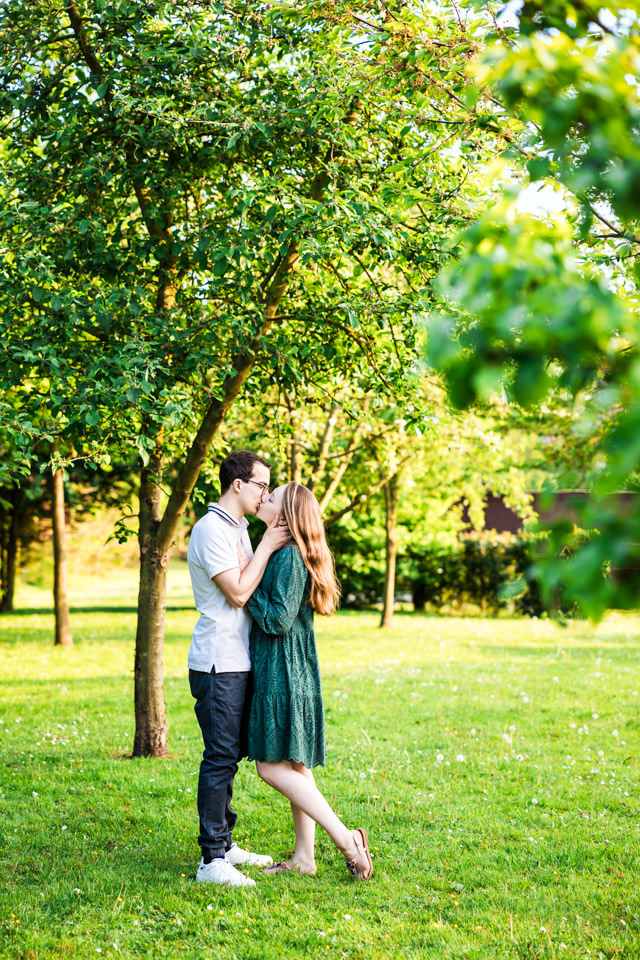 Paar küsst sich unter einem Baum beim Verlobungsshooting in Leopoldshöhe.
