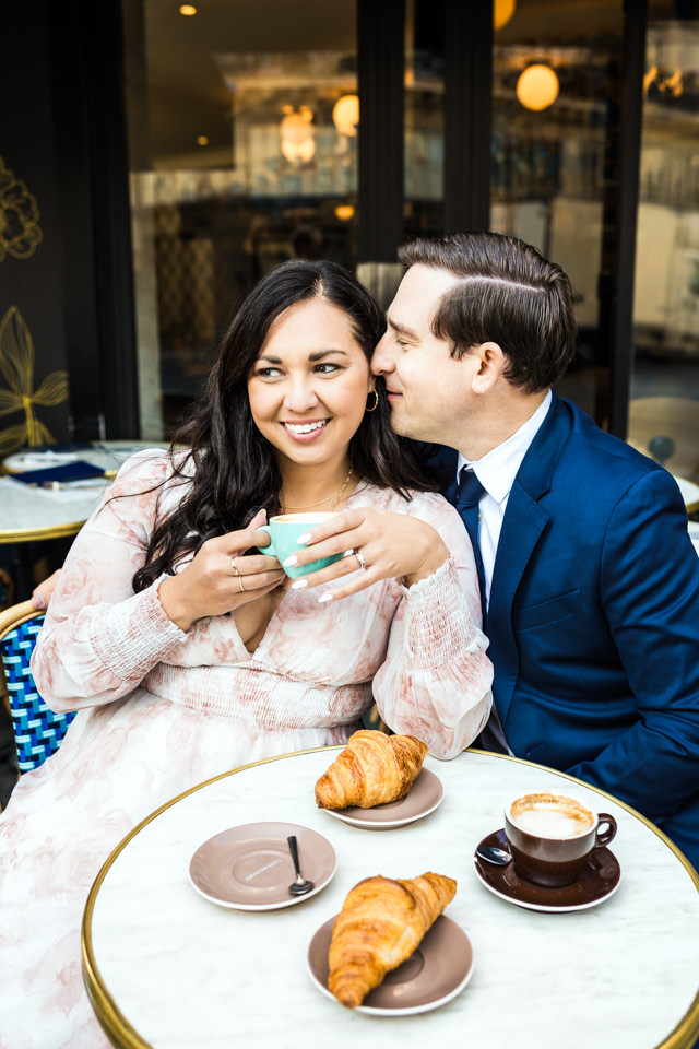 Das Pärchen legt beim Paarshooting in Paris einen Zwischenstopp in einem Café ein.